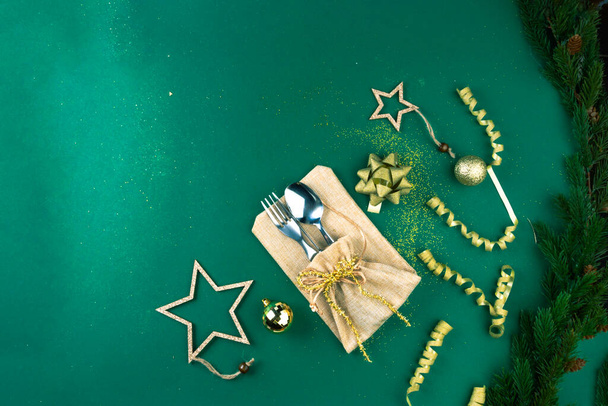Christmas Green Festive Background with Cutlery, Holiday Setting Decorated with branches, toy, gold sparkles - Valokuva, kuva