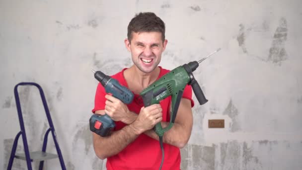 Portrét brutálního, veselého, šíleného muže s elektrickým nářadím při renovaci bytu - Záběry, video