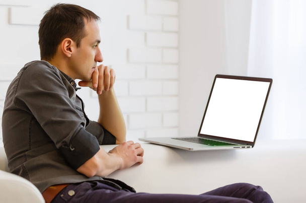 Задний вид мужчины, сидящего перед открытым ноутбуком с пустым экраном для информации или контента, современный бизнесмен, работающий в Интернете через ноутбук, студент в кафе обучения - Фото, изображение