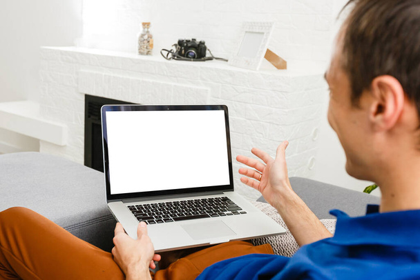 Back view of male person sitting front open laptop computer with blank empty screen for your information or content, modern businessman working in internet - Foto, immagini