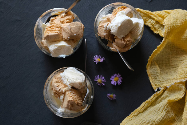 Ice cream cream in ice cream bowls on a dark slate background. - Fotó, kép
