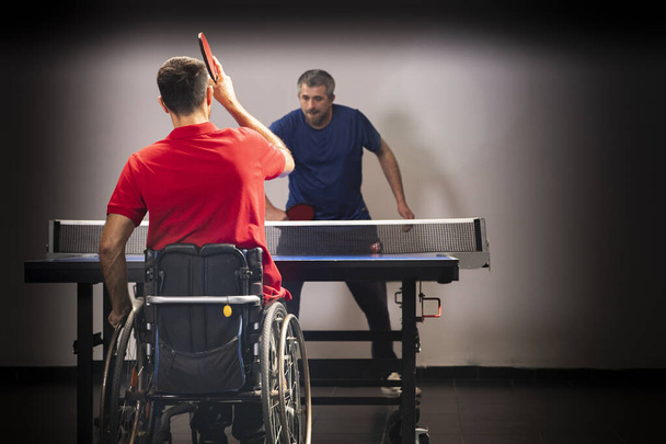 Utilisateur de fauteuil roulant avec une raquette de tennis dans leurs mains. Réadaptation des handicapés. Sport et mode de vie sain. Sports paralympiques.   - Photo, image