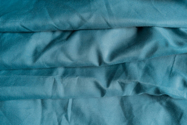 Modré plátno tvoří různé abstraktní vzory. modrá textura tkaniny, vlnitá tkanina - Fotografie, Obrázek