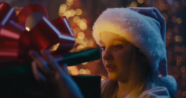 Εκπληκτικό κορίτσι που εξετάζει μαγικό χριστουγεννιάτικο δώρο - Πλάνα, βίντεο