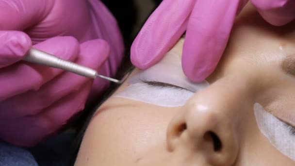 Moderni silmäripsien laminointi menettely ammatillinen kauneushoitola. Master soveltaa erityistä silikoni papiljotit ennen silmäripsien curling menettelyä - Materiaali, video