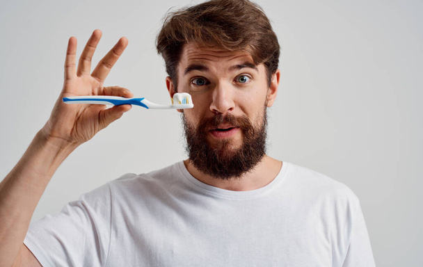 άντρας με οδοντόβουρτσα στα χέρια του μοντέλο οδοντόκρεμας στοματικής κοιλότητας - Φωτογραφία, εικόνα