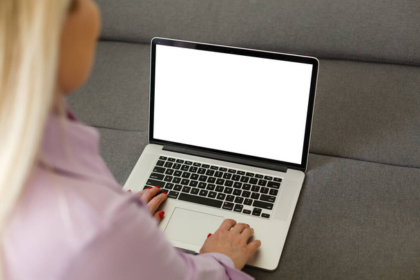 Οπίσθια όψη των γυναικών των επιχειρήσεων χέρια απασχολημένος με τη χρήση του φορητού υπολογιστή κενή οθόνη στο γραφείο, με copyspace - Φωτογραφία, εικόνα