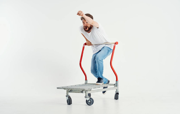mężczyzna w wózku towarowym na lekkim tle superbohater przewożący ciężkie przedmioty - Zdjęcie, obraz
