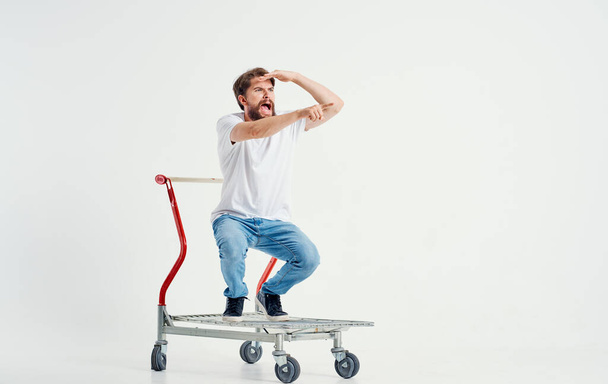 Cheerful Man Rides On A Cargo Cart In A Bright Room - Photo, Image