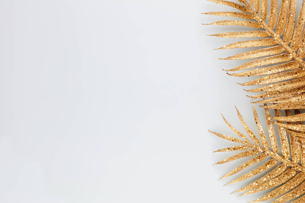  Palm gold leaf on blue background. Palm leaf, Flat lay and top view. - Фото, зображення