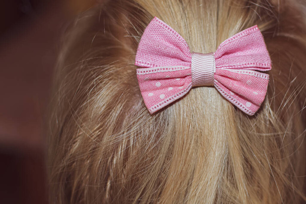 Vaaleanpunainen rusetti tytön hiuksissa - Valokuva, kuva