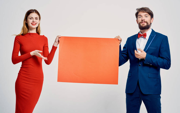 emotional man in a suit and bow tie with a mockup in his hands and a young woman - Foto, Bild