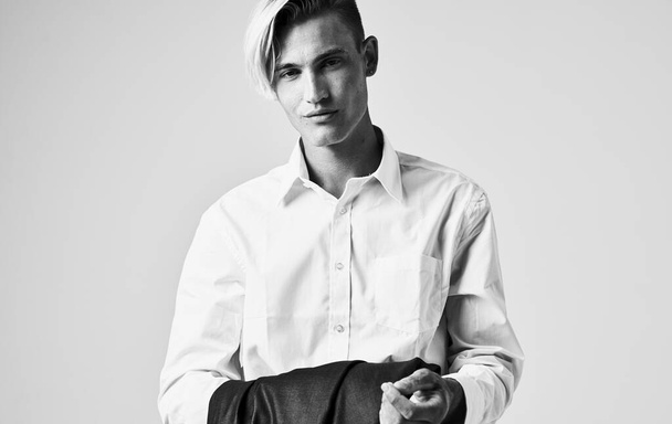 Uomo in camicia con una giacca in mano su uno sfondo grigio vista ritagliata - Foto, immagini