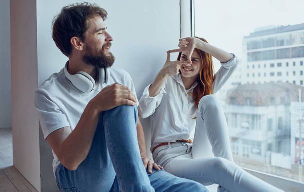 cheerful young couple sitting near the window technology communication interior - Photo, Image