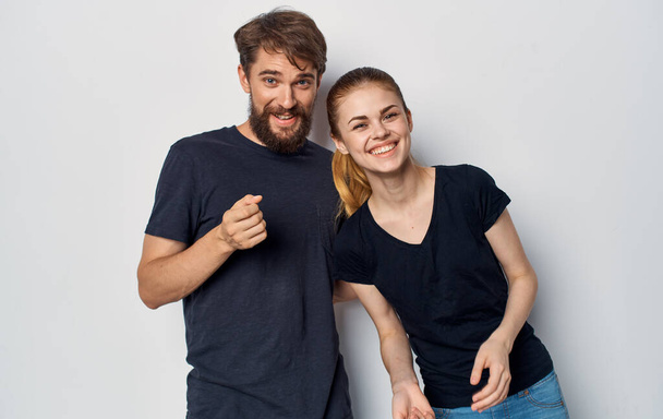 joven pareja en negro camisetas diversión emociones casual ropa estudio - Foto, imagen