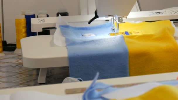 L'ago della macchina per cucire per ricamo fa un ornamento su un pezzo di tessuto azzurro e giallo. Speciale macchina da cucire per ricamo al lavoro. Macchina da cucire programmabile - Filmati, video