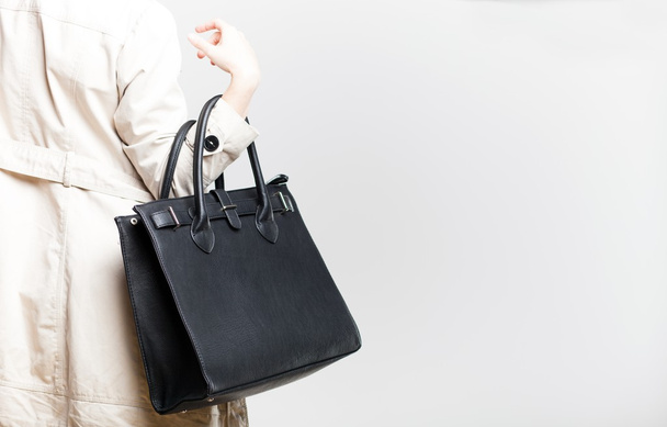 Fashionable woman with black bag, back view - Foto, Imagen