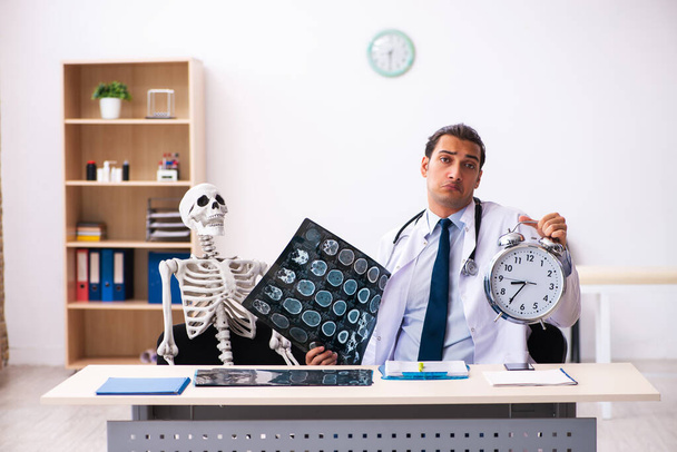 Jovem médico radiologista e paciente esqueleto na clínica - Foto, Imagem