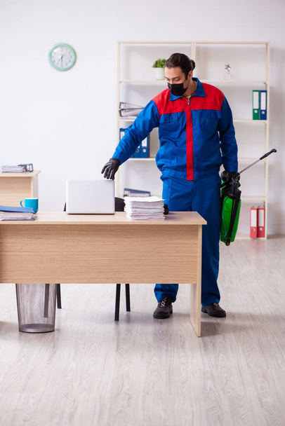 Young male contractor disinfecting office - Photo, Image