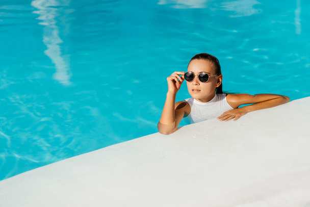Young woman relaxing in swimming pool on summer vacation. - Photo, Image