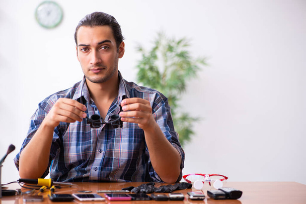 携帯電話を修理する若い男性技術者 - 写真・画像