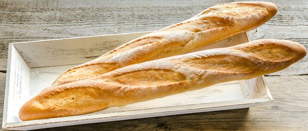 Two baguettes on the wooden tray - Photo, Image
