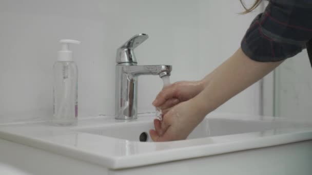 手のきれいなぬれた肌を注意深く見て結果をチェックするよりも、石鹸と新鮮な水を使用して手を洗う女性. - 映像、動画