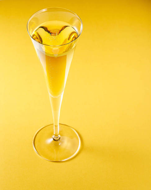 glass of champagne on yellow background - Photo, Image