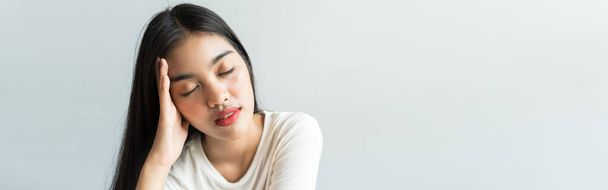 A zászlós ázsiaiak a fejfájások miatt tartják a fejüket. Lázas és migrénje van a stressz vagy a hosszú alvás miatt, rossz alvás, elégtelen pihenés az egészséges koncepcióban, másolási hellyel. - Fotó, kép