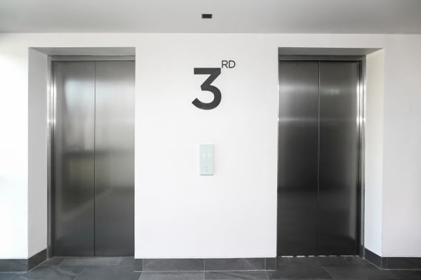 Две серебряные двери лифта в Белом коридоре. - Фото, изображение