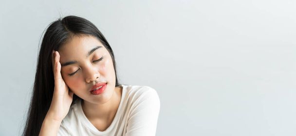 Asiatische Frauen tragen eine Gesichtsmaske halten ihre Köpfe wegen Kopfschmerzen. Sie hat Fieber und Migräne aufgrund von Stress oder Schlaf spät, wenig Schlaf, unzureichende Ruhe in gesundem Konzept mit Kopierraum - Foto, Bild