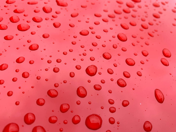 Padrão de gota de água no capô do carro vermelho, capota. - Foto, Imagem