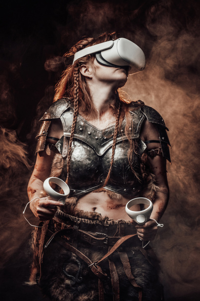 Guerriera vichinga femminile con auricolari di realtà virtuale e joystick - Foto, immagini