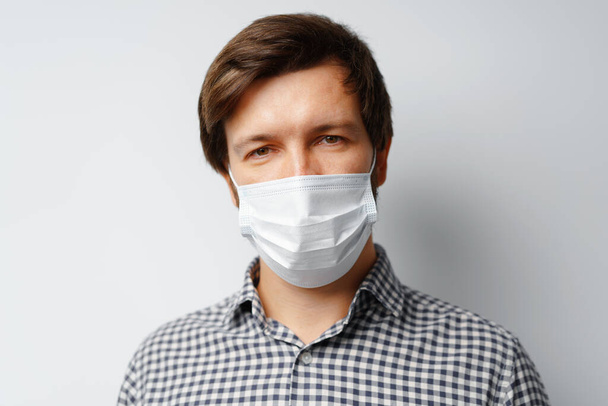 Man wearing hygienic mask against grey background - Zdjęcie, obraz