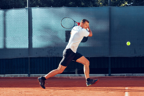Tennisprofi schlägt während Match einen Ball ab - Foto, Bild