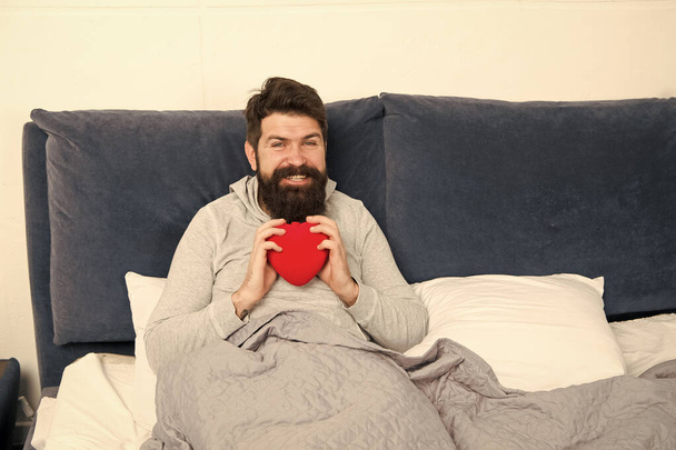sweet heart. morning surprise from his valentine. happy valentines day. bearded man hold decoration heart in bed. heart full of love. start day with romantic. hipster with present - Foto, Imagen