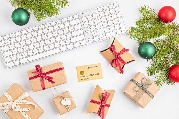 Online vánoční nákupní koncept s dárkovými krabicemi, klávesnicí a zlatou kreditní kartou. Top view, flat lay, maket up - Fotografie, Obrázek