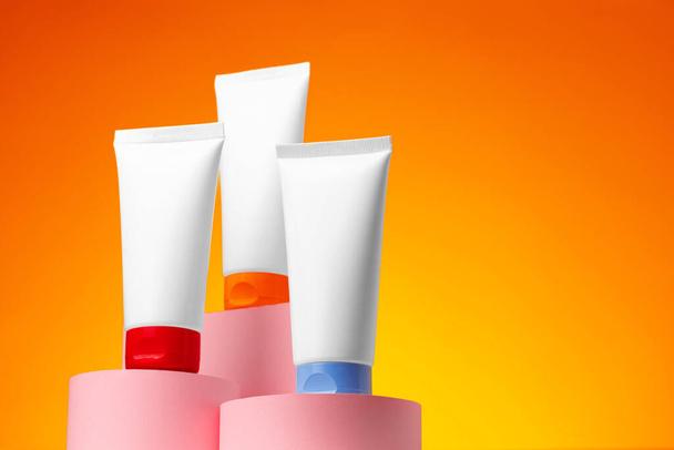 Blank white cosmetic container against orange background - Zdjęcie, obraz