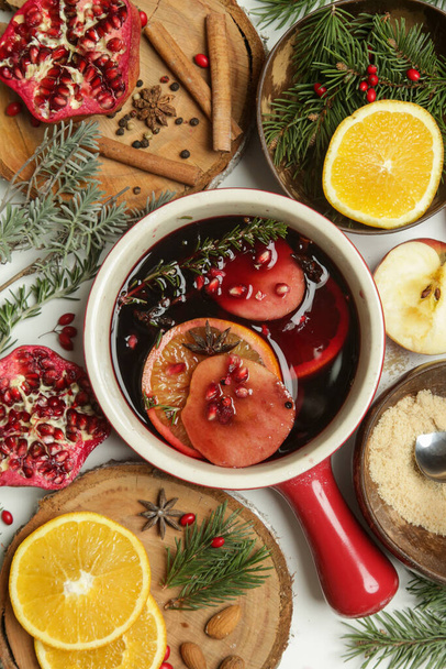 Spicy mulled wine with ingredients around. Pot of mulled wine, traditional christmas drink. - Photo, image