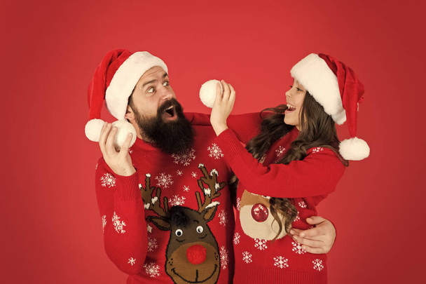 Having fun together. Greeting xmas tradition. happy family play snowball. father and daughter celebrate new year. family holiday fun. small girl and santa dad red background. merry christmas everyone - Фото, изображение