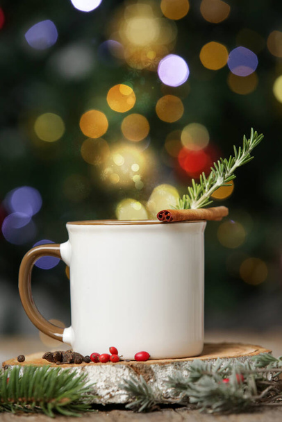 背景にクリスマスツリーボケライトとお祝いの配置で空白の白いセラミックカップ. - 写真・画像