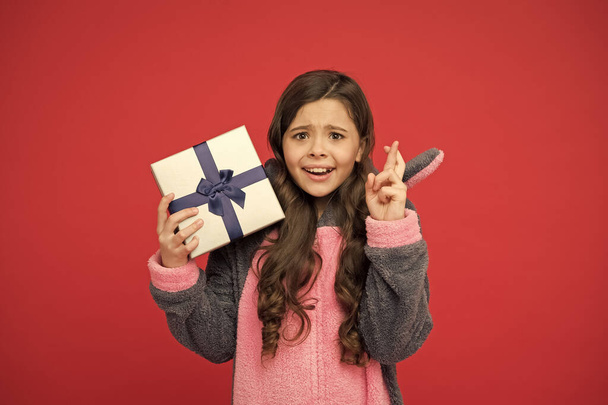 Mysterious present. Happy child cross fingers with present. Little girl hold present box. Birthday present. Gift delivery. Boxing day. Feast or festival. Holiday celebration. Black Friday sale - Foto, Bild