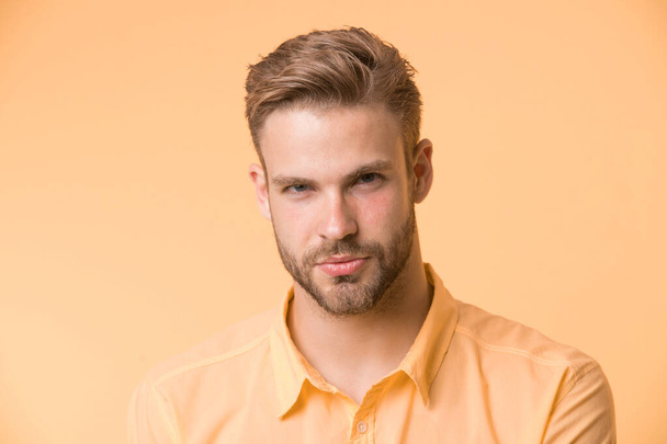 Man with bristle on confident face, yellow background. Skin care concept. Man with beard or unshaven guy looks handsome and well groomed. Guy bearded and attractive cares about his appearance - Foto, Bild
