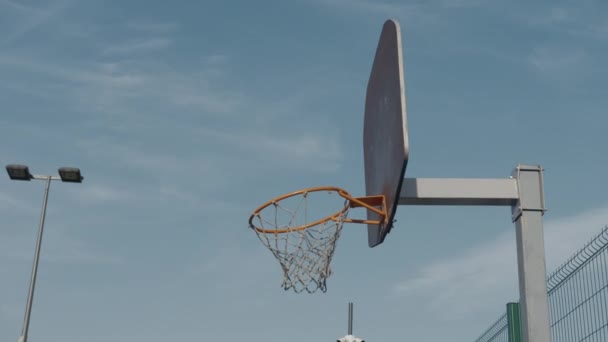 Basketbal mand op blauwe lucht achtergrond - Video