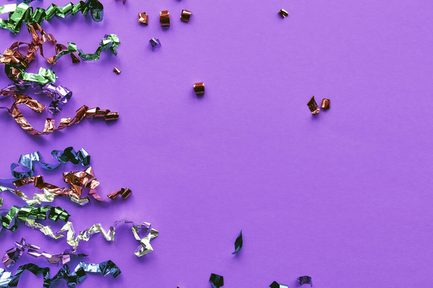 Fiesta de confeti colorido sobre fondo de papel pastel. Chispas, purpurina, elementos de oropel marco de celebración de año nuevo. Colocación plana, vista superior, banner de espacio de copia. - Foto, imagen