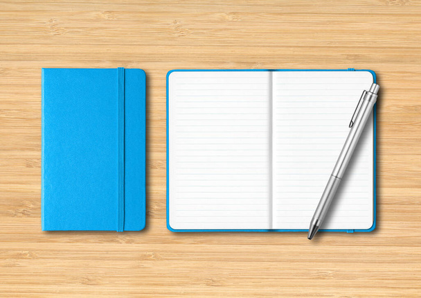 Blue closed and open lined notebooks with a pen. Mockup isolated on wooden background - Φωτογραφία, εικόνα