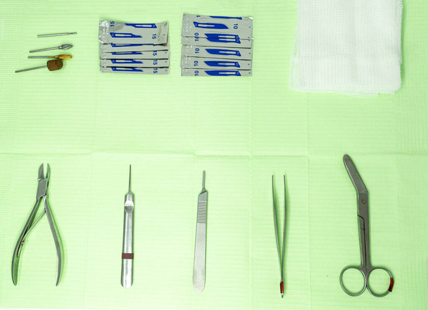 Widok z góry materiału podiatrii na stole roboczym. Widzimy nożyce, żłobek, skalpel, szczypce i nożyczki. - Zdjęcie, obraz