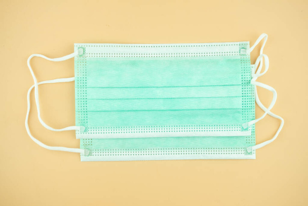 Medical sterile protective green masks on a yellow background - Foto, imagen