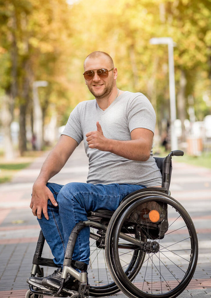 Handicapped man in wheelchair walk at the park alley - Foto, afbeelding