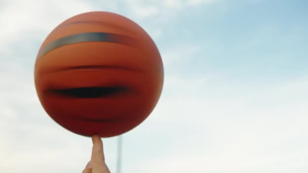 junger Mann mit einem sich drehenden Ball am Finger, Nahaufnahme - Filmmaterial, Video